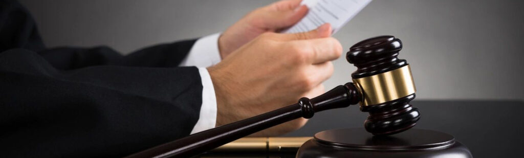 A judge holding his hands over the gavel